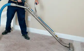 Professional operating a liquid removal machine on a carpeted floor in Fort Worth, TX